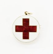 Gold-coloured enamel brooch pendant of WW1 interest, the circular form enamelled with a red cross on