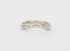 18ct white gold and diamond wedding ring with slight curve set with five diamonds in rubover