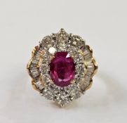18ct gold, ruby and diamond dress ring, the oval ruby surrounded by inner border of circular