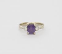 18ct white gold, purple sapphire and diamond three-stone dress ring, the rounded rectangular