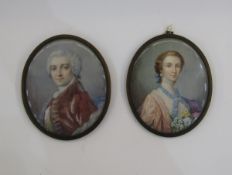 Pair of portrait miniatures depicting a lady and gentleman in the 18th century-style, he in a red