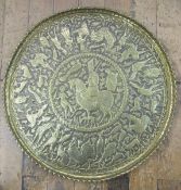 Middle Eastern, possible Qajar, embossed brass charger of circular form with scalloped edge, the