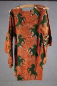 A vintage bespoke made long top with orange and black abstract design and green rearing horses.