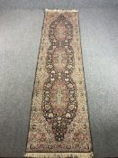 A Persian runner with scrolling foliate medallions on a midnight ground within naturalistic