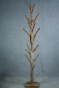 A hall coat and hatstand cut from a hardwood branch with a lacquered finish. H.204cm.
