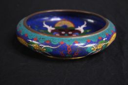 An antique Chinese cloisonné shallow bowl decorated with a dragon. Enamelled in bright blues, yellow