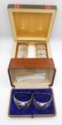 Two cases of silver napkin rings, a set of eight oval Indian silver napkin rings with relief