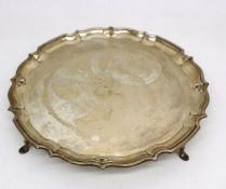 An Edwardian four footed silver tray by Barker Brothers. The tray has a scalloped ridged edge and