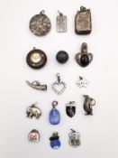 A collection of charms and silver pendants, including an Art Nouveau locket pendant, the front