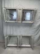 A pair of distressed painted window frames with louvre shuttered doors, each fitted with a pair of
