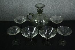 A Swedish smokey etched glass spherical decanter with conical stopper and four matching glasses