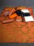A gold and pink silk brocade bed throw with scrolling foliate design along with two coral bolster