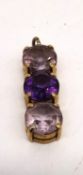 A 9ct yellow gold three stone amethyst and pale pink stone pendant by Tony Bestwick. The pendant set
