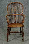 A 19th century elm and yew Windsor armchair with hooped back and pierced splat on turned stretchered