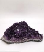 A large amethyst crystal geode cluster. L.27 x W.27cm H.8.5cm