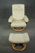 A contemporary Stressless leather upholstered reclining armchair and matching stool. H.101cm.