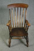 A 19th century elm seated stick back kitchen chair.