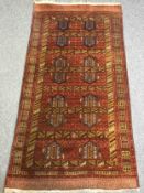 A Shirvan carpet, burgundy field within stylised multiple borders. L.190 W.102cm.