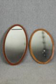 Two oval mirrors, one in oak, the other walnut, with bevelled glass H.95 W.55cm.
