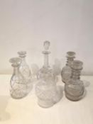 A collection of six hand cut glass and crystal decanters, including a pair of Georgian decanters