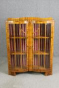 An Art Deco double bow fronted walnut display cabinet. H.126 W.100 D.32cm.