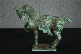 A Chinese Tang style bronzed metal model of a horse, with verdigris patination. H.22cm.