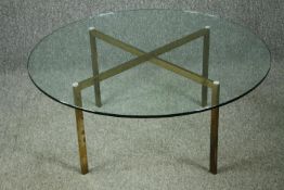 A vintage glass coffee table on brass supports. H.39 Dia.91cm.