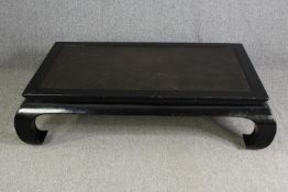 A Chinese style black lacquered low coffee table (missing glass), H.38 W.140 D.95cm.