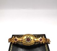 An Edwardian 9ct rose gold ruby and seed pearl bracelet with beaded detailing and wire work
