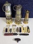 Three miner's lamps, including a Thomas and Williams, J H Naylor of Wigan, and another. Largest is