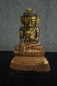 † A 19th century Chinese painted and gilded ceramic buddha in lotus position. H.39cm.