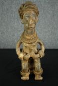 † A Nigerian clay figure with traditional headdress and bangles. H.47cm.