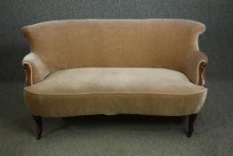 An Edwardian walnut settee on cabriole legs, in beige upholstery. H.74 W.146 D.70cm.