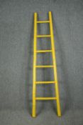 A yellow painted bamboo ladder. H.197cm.