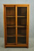 A mid 20th century teak bookcase, with sliding glazed doors. H.152 W.85 D.42cm.