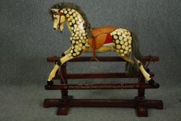 An an early 20th century rocking horse by Collinson, painted in dapple grey with a tan leather