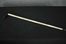 † A Batak bone walking cane, with stylized decoration. L.88cm.