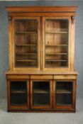 A Victorian walnut library bookcase with glazed doors. (In two main sections). H.233 W.161 D.50cm.