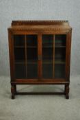 An early 20 century oak bookcase, with glazed doors. H.122 W.93 D.31cm.