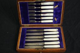 An early 20th century set of silver plate cake knives and forks with mother of pearl handles in a