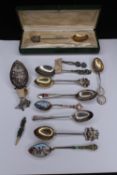 A collection of vintage white metal and enamelled commemorative teaspoons, mainly from the east (