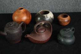 Three Chinese Yixing teapots, and three small clay bowls. H.11cm. (largest).