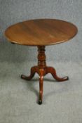 A Georgian oak tilt top centre table. H.69 Dia.77cm.