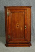 A George III oak hanging corner cupboard, with conch shell inlay. H.108 W.70 D.41cm.