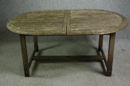 An extendable weathered teak garden dining table with an additional leaf. H.72 W.210(ext) D.109cm.