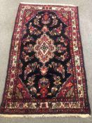 A 20th century Persian Hamadan rug with a blue ground and floral decoration. L.180 W.107cm.