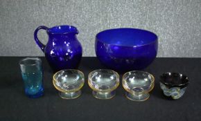 A group of glass wares, including a Bristol blue salad bowl and jug, four small bowls and a drinking