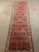 A North West Persian runner with a terracotta field. L.290 W.83cm.