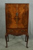A mid 20th century figured walnut drinks cabinet with mirrored interior, H.138 W.70 D.47cm.