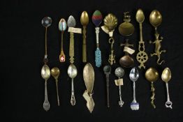 A collection of brass, white metal and enamelled commemorative teaspoons from around the world. L.